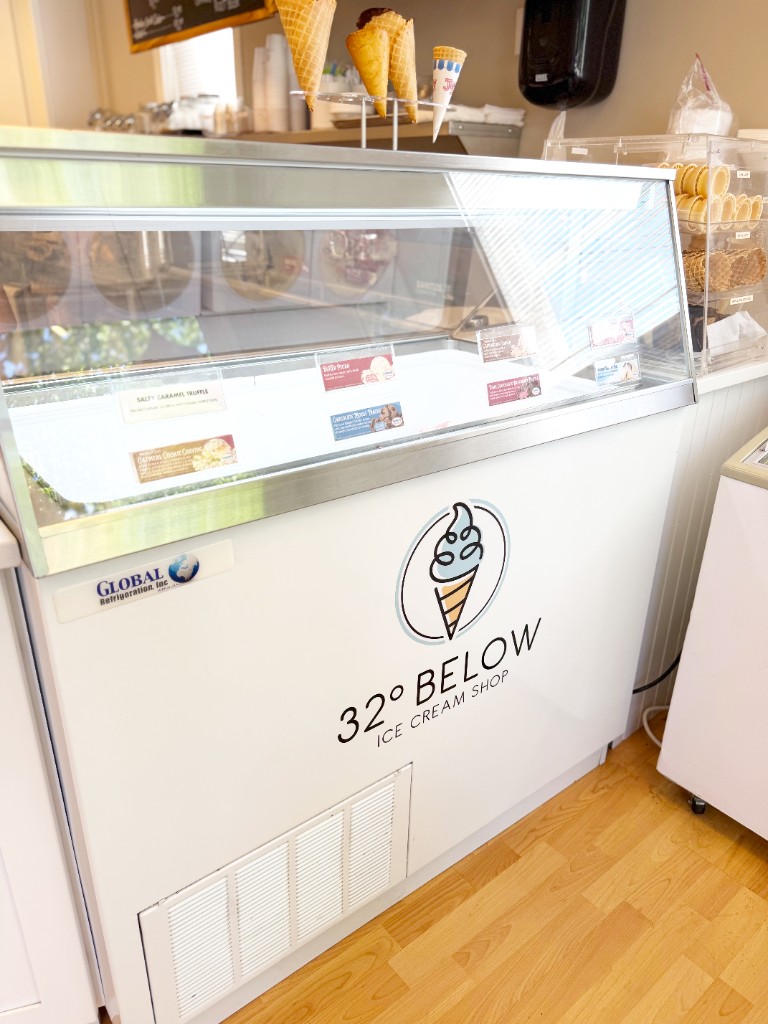 Hand-dipped ice cream cabinet with waffle cones and 32° Below branding at the counter