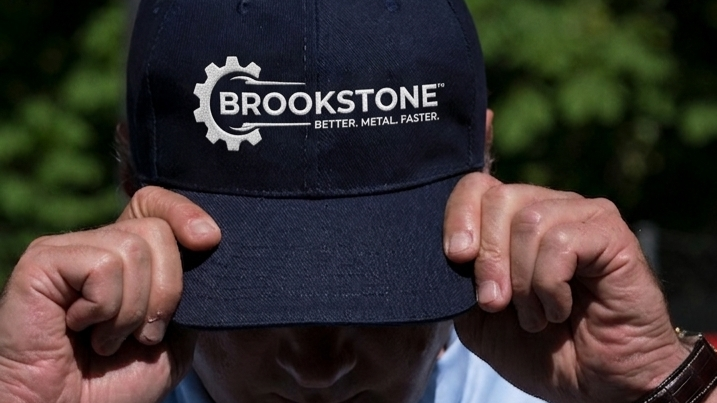 Brookstone Industries embroidered logo on a navy cap outdoors