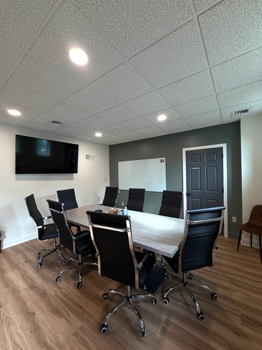 Hatchworks conference room with wood-grain table and black executive chairs
