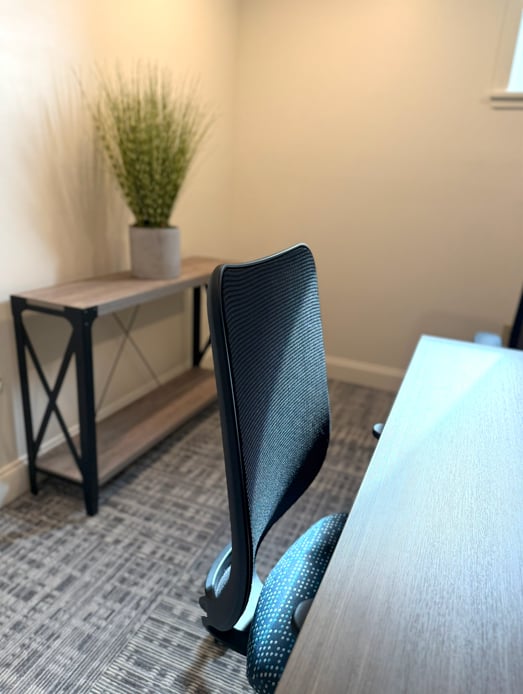 Open workspace desk and mesh office chair at Hatchworks