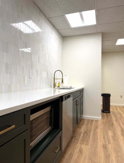 Hatchworks kitchenette with picket-tile backsplash and stainless appliances