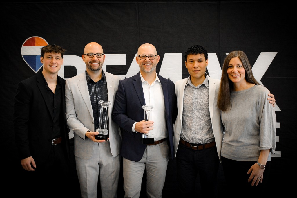 RE/MAX Pinnacle agents celebrating with matching crystal trophies at an awards event